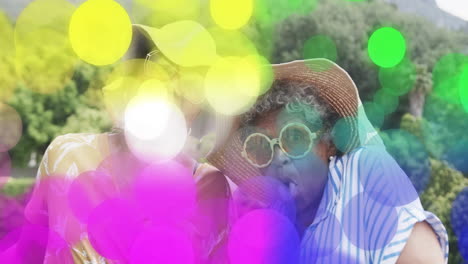 colorful bokeh animation over two people wearing hats and sunglasses outdoors