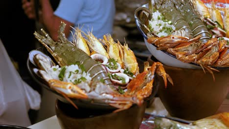 Street-food-stall-Buckets-fresh-seafood-on-local-market-Ratchada,-Bangkok