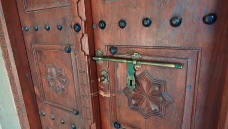 an antique wooden door inside a traditional arab house in sharjah, uae.