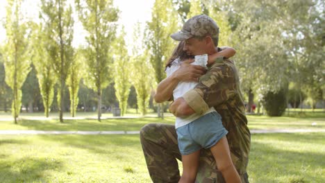 chica emocionada corriendo hacia los brazos abiertos de papá militar