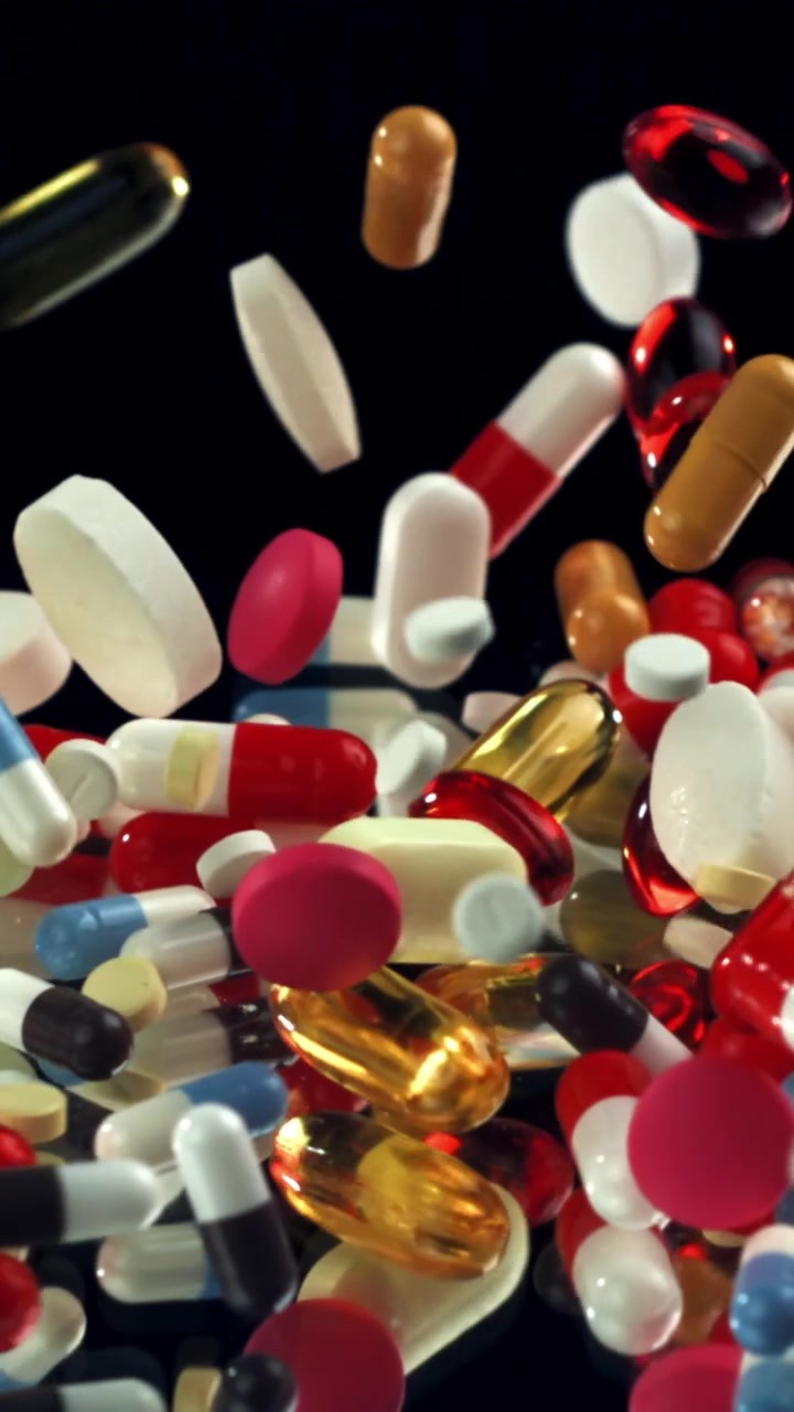 Assortment of Colorful Pharmaceutical Pills Falling on Black Background