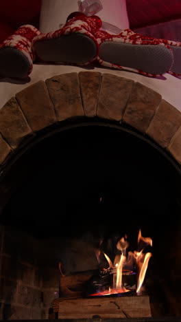 burning fire in the fireplace. low angle view of the fireplace with medium size flames. flame burns in the fireplace at night and making a comfort. vertical video