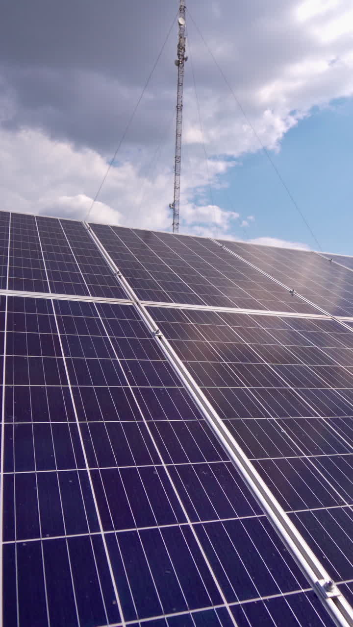Close-up solar panel at sunlight. Alternative source of energy. Innovative solar cell panel under the sky on the field. Photovoltaic system. Vertical video