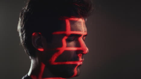 facial recognition technology concept as man has red and green grids projected onto eye in studio