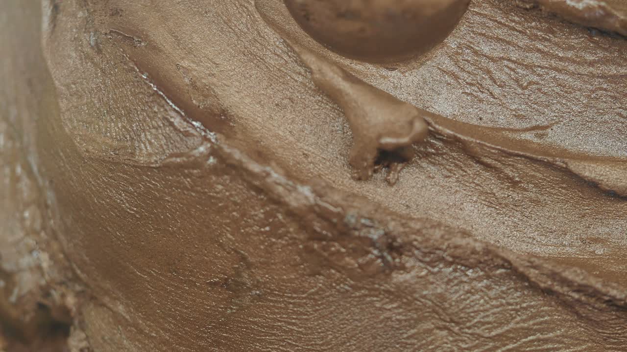 Primo piano di glassa al cioccolato che viene spalmata