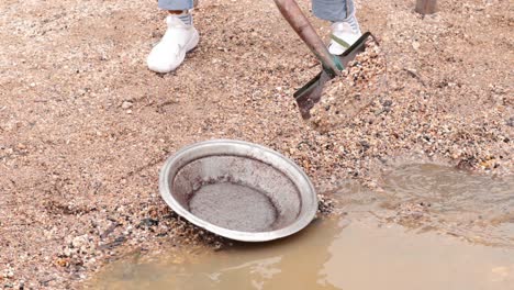 persona buscando oro en aguas fangosas