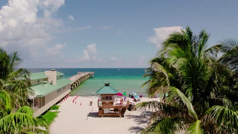 drone beach view with pier, blue ocean waters