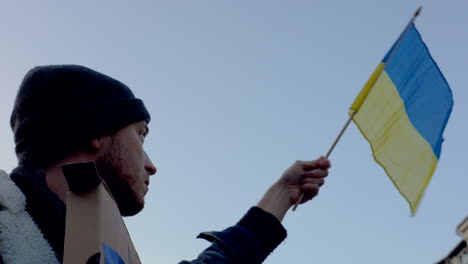 Protester-waving-Ukrainian-flag-at-demonstration-against-war,-Prague