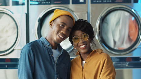 retrato de una feliz y alegre pareja enamorada abrazándose y sonriendo a la cámara en el servicio de lavandería