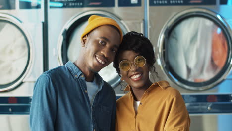 portrait of happy cheerful couple in love hugging and smiling to camera in laundry service