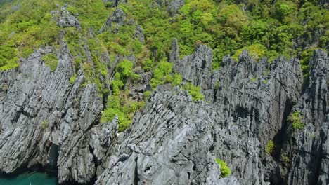 aerial view : flying over interesting rock formations surrounding the secret beach, a tropical shallow swimming lagoon, popular tourist attraction of island hopping tour c in el nido, philippines