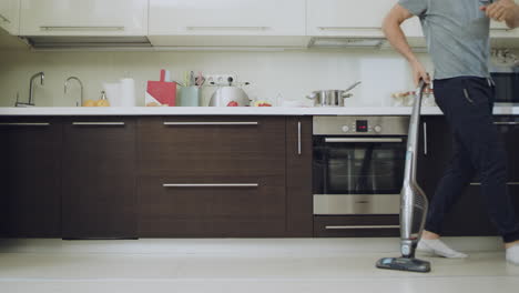 Happy-man-cleaning-floor-doing-zigzag-moves-with-vacuum-cleaner.