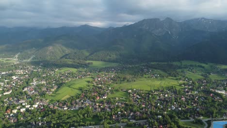 Landscape-flyover-of-Polish-Tatry-Mountains,-farmland,-forests,-and-legendary-Giewont-peak-near-Zakopane,-Poland,-a-resort-town-with-traditional-Goral-architecture---4k-30fps-Smooth-Tracking-Right