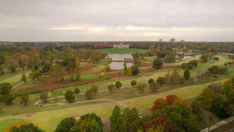 aerial over forest park with a slow push towards the grand basin and the saint louis art museum on a beautiful cloudy day in autumn in st