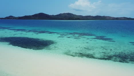 drone arrecife de coral de fiji relajándose para bucear banco de arena blanca isla de malalo agua azul profundo hombre caminando paisaje escénico soleado hermoso relajante nadi movimiento circular cinematográfico aéreo