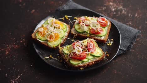 healthy toasts with cucomber  tomatoes and crumbled feta and radish sprouts