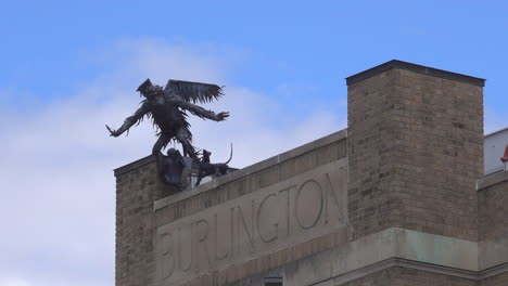 una estatua de metal de un mono volador adorna el techo de un edificio en burlington, vermont