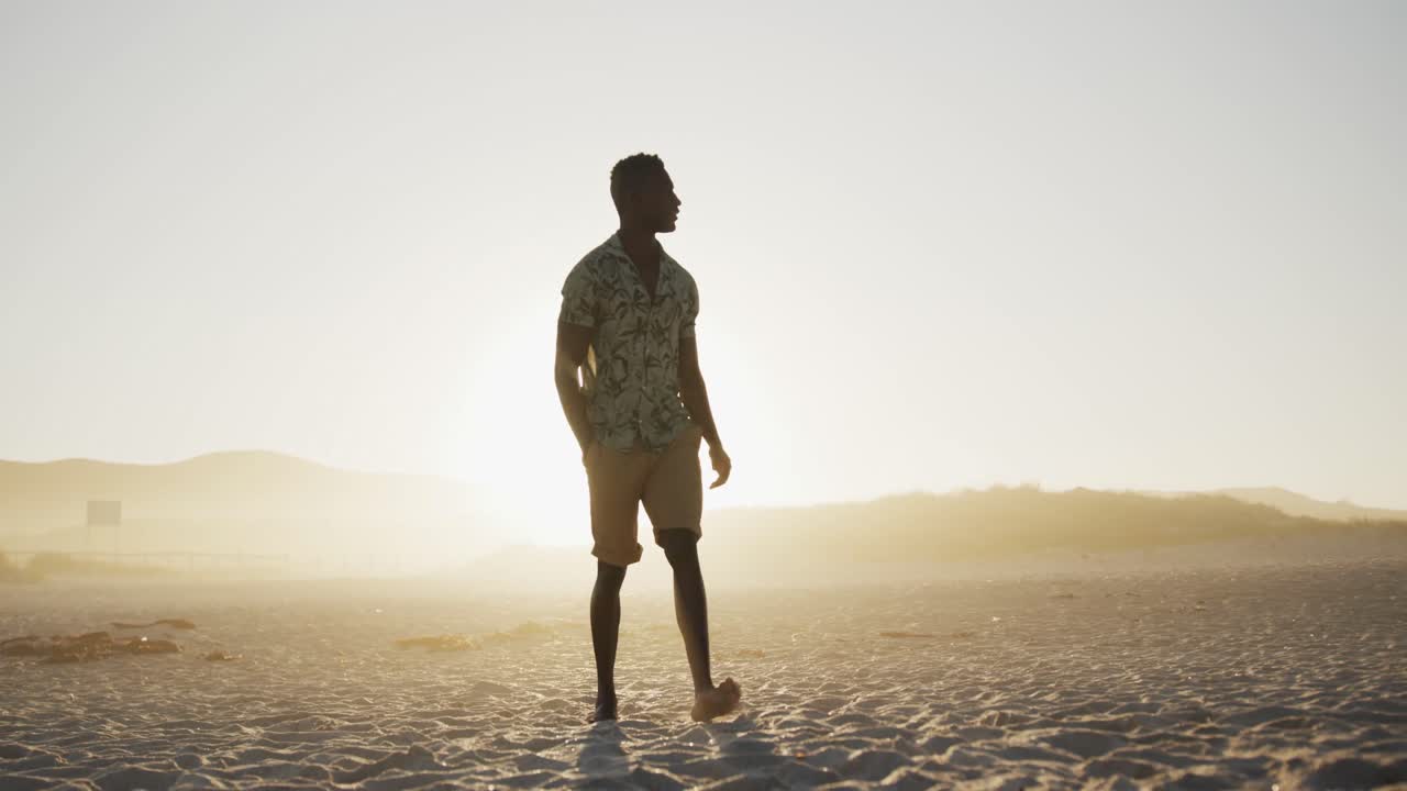 African American man walking at beach