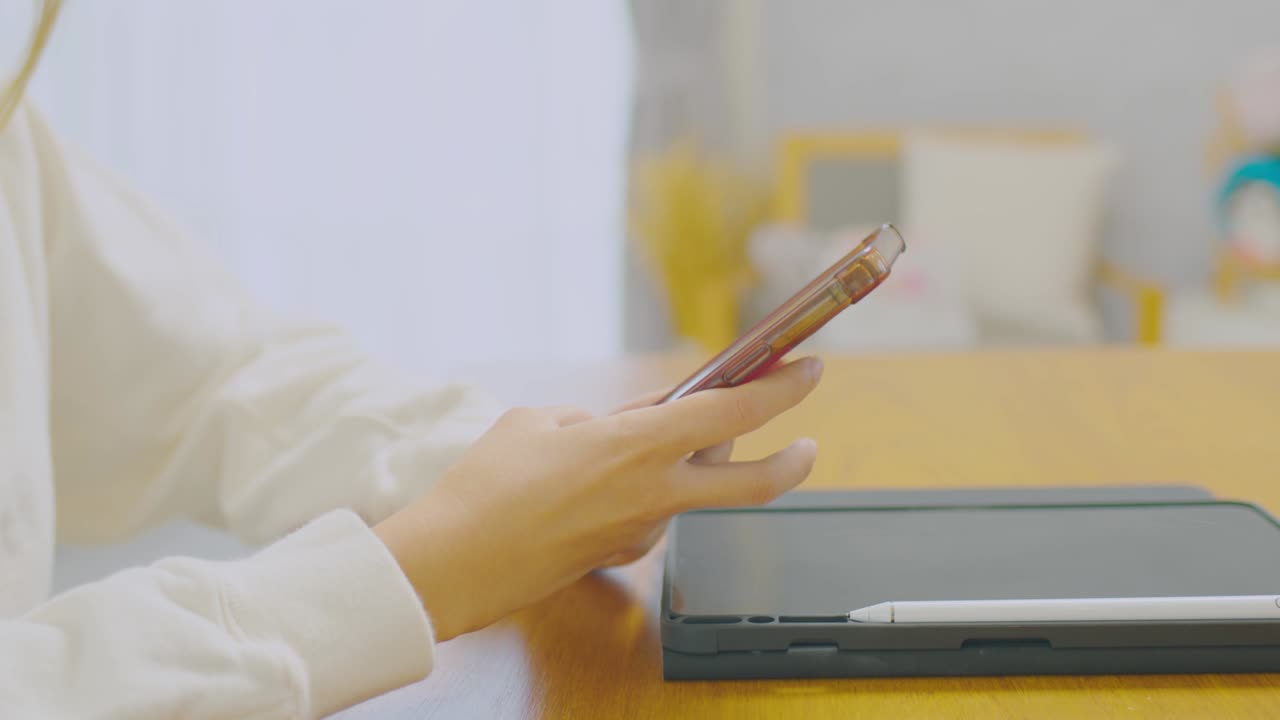 가까운 손: 스마트 폰을 사용하는 아시아 소녀가 게임과 소셜 미디어를 사용하거나 친구들과 채팅합니다.