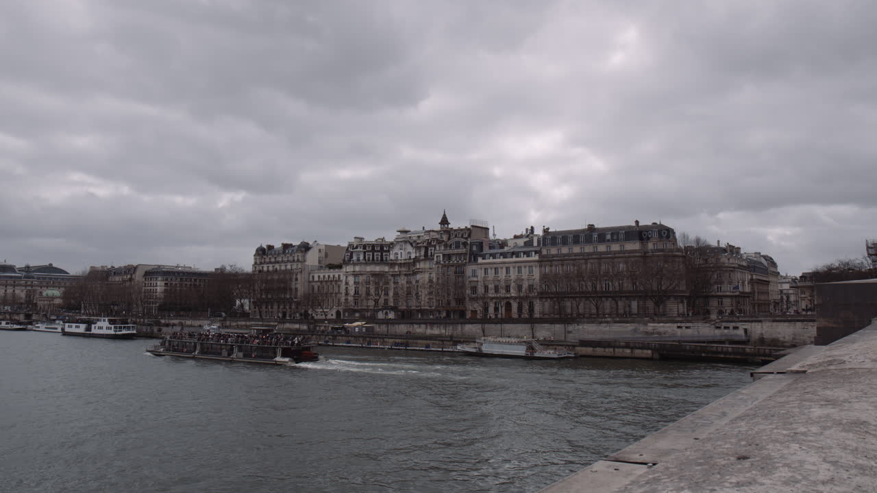 프랑스 파리의 구름이 많은 날 에 세인 강 을 항해 하는 여객 보트