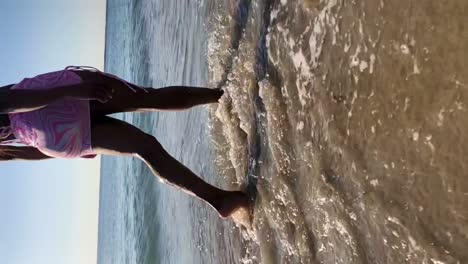 mujer negra anónima caminando por la playa