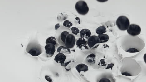 closeup blueberry falling yogurt in super slow motion. delicious milky cocktail.