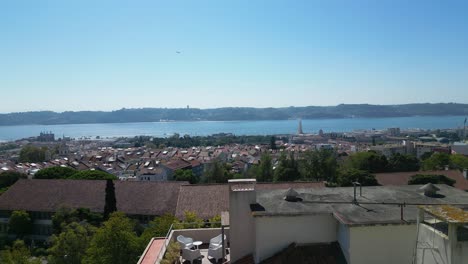 Aerial-reveal-shot-of-the-city-of-Lisbon-in-Portugal-with-the-Tagus-River-in-the-background