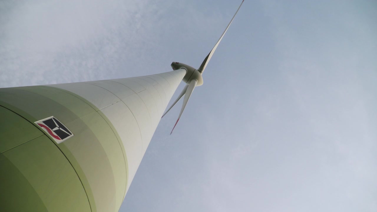 Perspectiva de rana de una turbina eólica generando energía