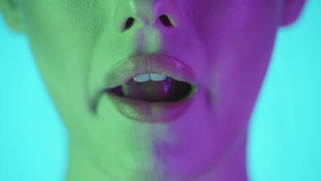 extreme close up of beautiful woman lips while she smiles at you first and then chews a gum and enjoys the taste against turquoise background in slow motion