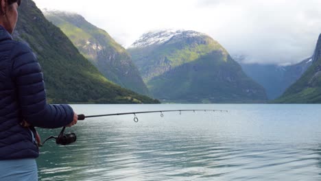 Woman-fishing-on-Fishing-rod-spinning-in-Norway.