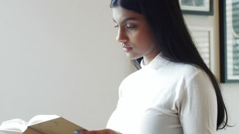 mujer leyendo una novela en la sala de estar