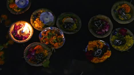 beautiful candle and flower offerings floating on the river - varanasi, india