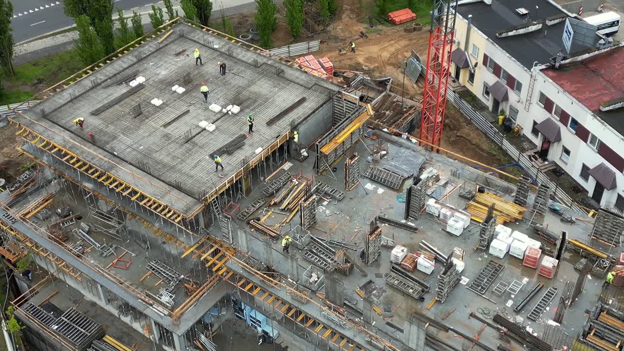 Top View of Building Under Construction with Reinforcement Bars and Laborers