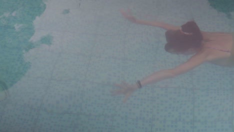 Handheld-shot-of-a-young-lady-in-a-swimsuit-swimming-underwater