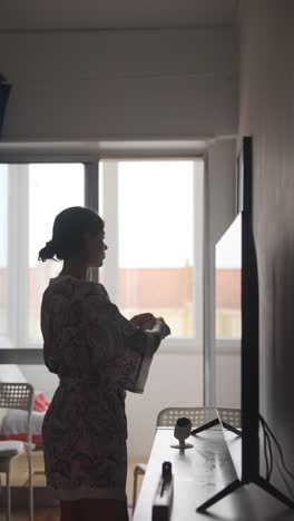 woman cleaning tv in bedroom