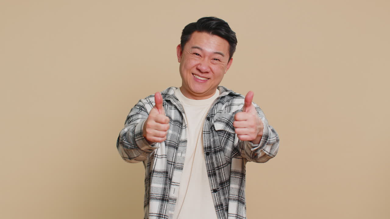 Asian blogger man pointing down saying to subscribe gesturing ok like showing place for information