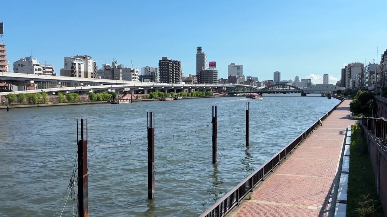 Vista di un fiume con lo skyline della città a Tokyo, Giappone, caratterizzato da ponti ed edifici.