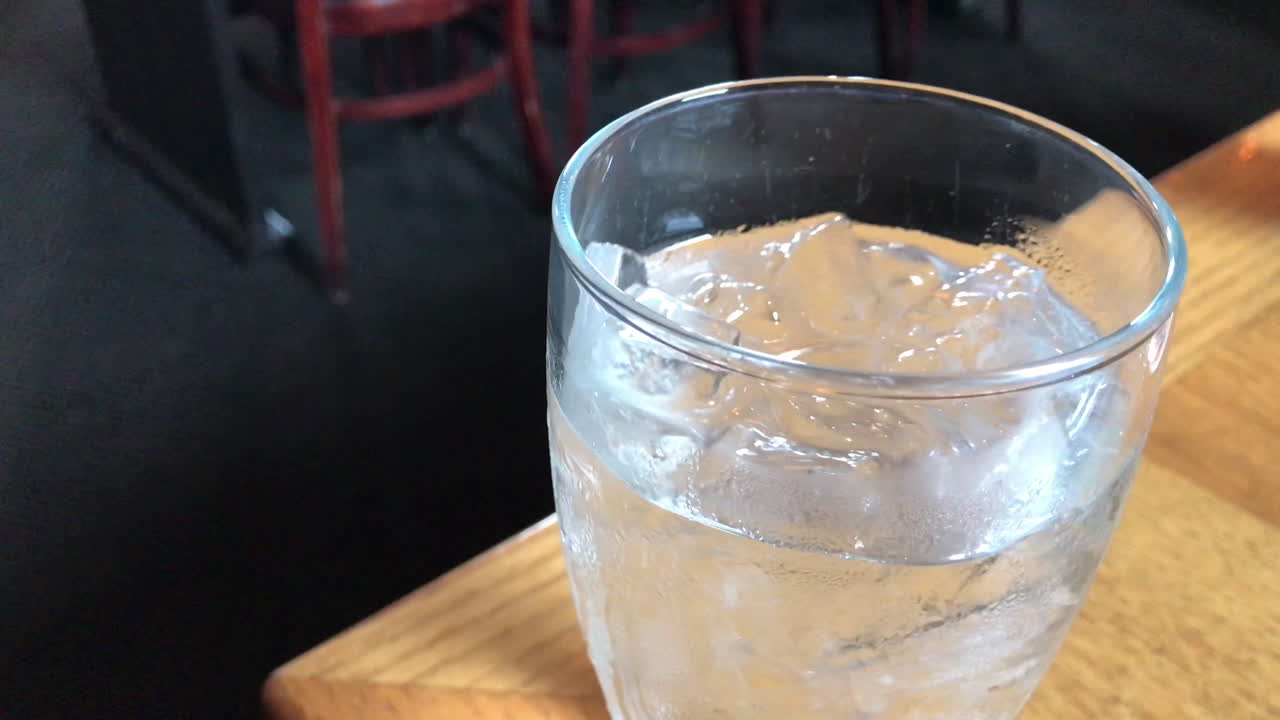 웨이트리스가 지나가는 레스토랑 테이블에 얼음물을 회전