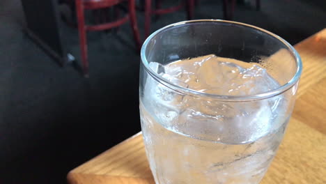 spinning ice water on a restaurant table with waitress walking by