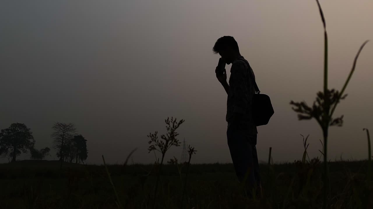 저녁에 스마트폰을 사용하는 사람의 실루 - 시골 통신 개념