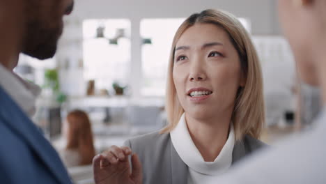 beautiful asian business woman chatting with clients smiling enjoying developing corporate partnership discussing project in modern office workspace