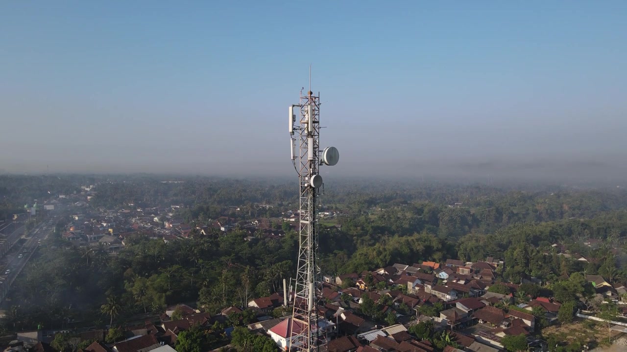 Riprese drone 4K mostrano torri di rete in un'area distrettuale, in Indonesia