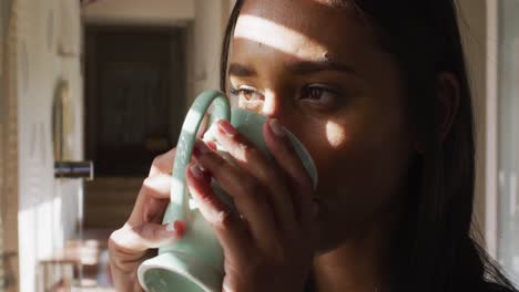 Portrait-of-mixed-race-woman-drinking-a-cup-of-coffee