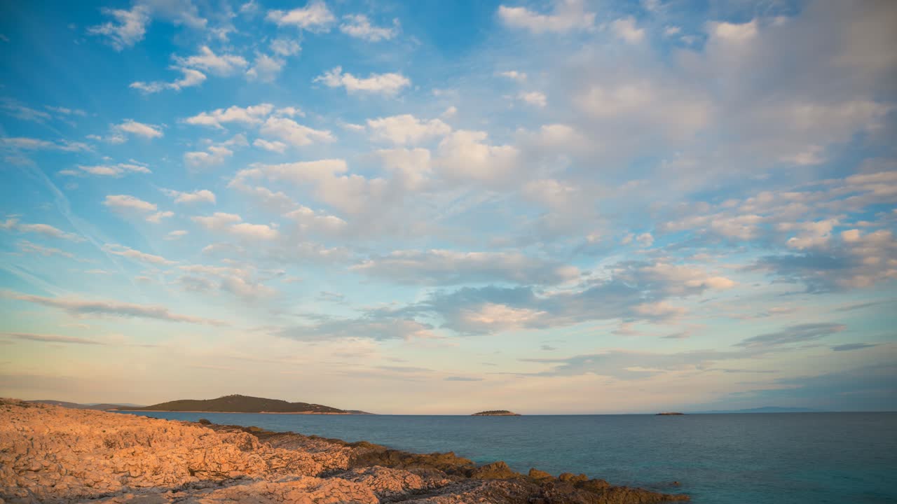 Scenic time lapse with blue sky cloud movement over rocky beach on the Adriatic coast near Split, Croatia