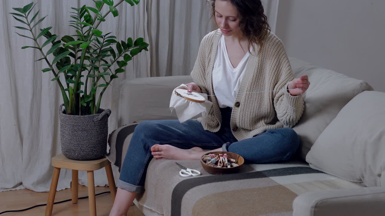 joven feliz cosiendo en las comodidades de su apartamento