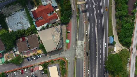 Aerial-til-up-shot-of-E37-Salak-highway-at-Seputeh,-Kuala-Lumpur,-leading-to-Lebuhraya-Persekutuan-slow-revealing-the-skyline-with-residential-apartments-and-Mid-valley-Megamall-shopping-mall