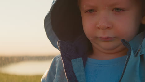 droplets trace down despondent boy face closeup forsaken little boy head bowed sheds tears alone