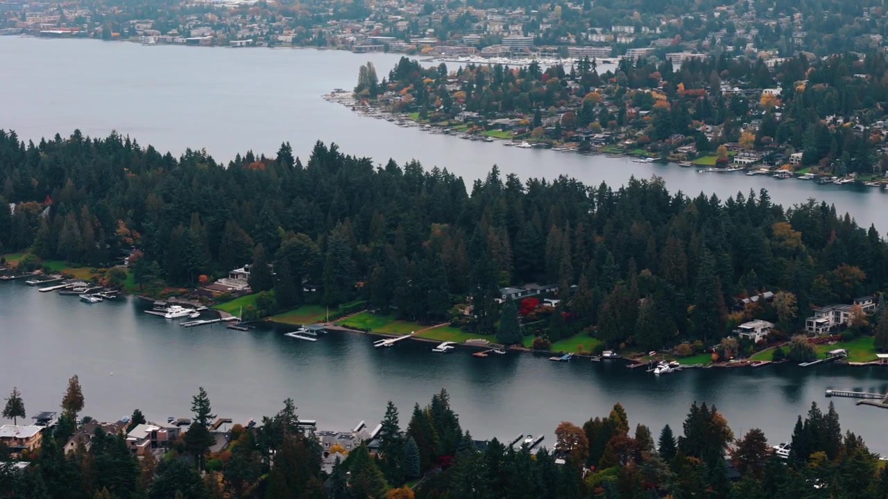 Il Lago Washington si snoda tra alberi autunnali e case lussuose in movimento.