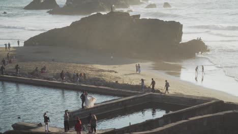 tourists and a married couple enjoying the sutro baths, a san francisco landmark, during an evening in california