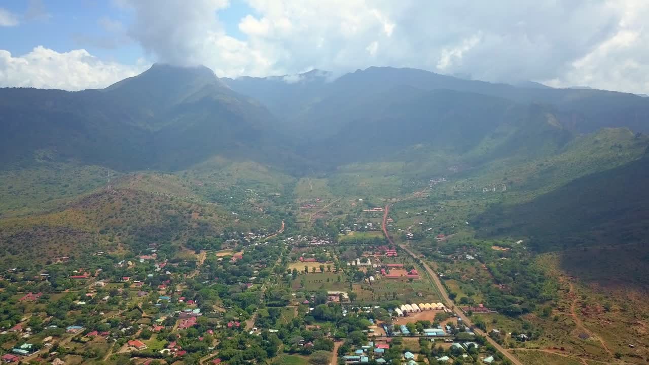 Aerial view of Moroto town, nestled in a valley with the impressive Mount Moroto dominating the background, showcasing the unique landscape of Uganda, Africa, slow motion drone shot